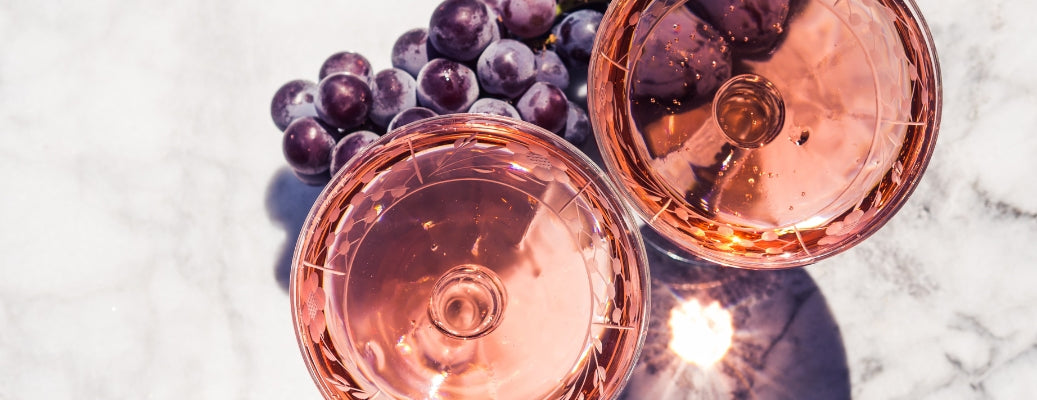 Two glasses of rosé wine and grapes, shot from above