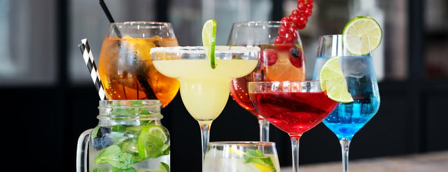 A group of colourful cocktails in various glasses