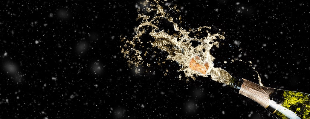 splashing champagne from a bottle on a black background