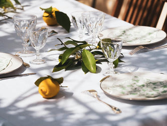 A sun dappled table set for a lunch or dinner